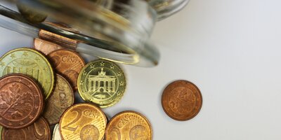 Verschiedene Euromünzen liegen unsortiert auf einem Tisch
