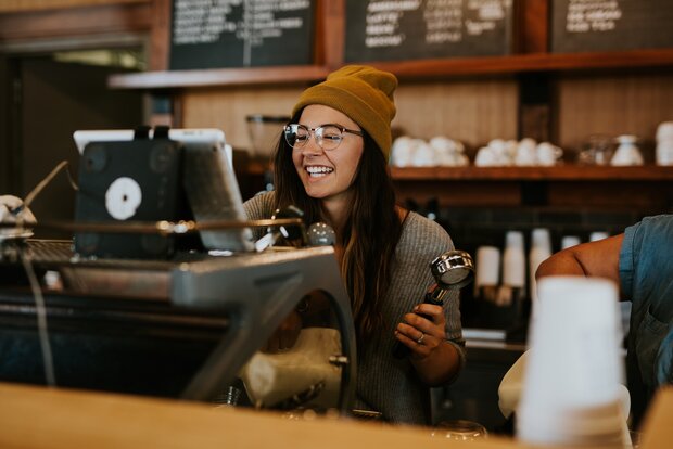 Junge weibliche Person jobbt in einem Café