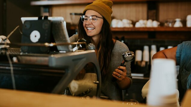 Junge weibliche Person jobbt in einem Café