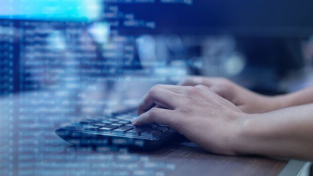 Hände schreiben auf einer Computertastatur